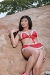 Asian model Lily Thai is playing with red bikini uncovering nudity outdoor