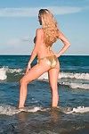 性感的 浓郁的 长腿 模型 安妮塔 黑暗 在 比基尼 姿势 上 的 海滩 通过 的 大海