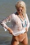 Slim blonde babe Wiska poses nude and in wet white blouse at the seaside